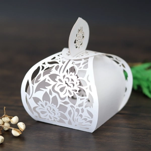 Macro view of white laser-cut floral pattern and hollow detail on wedding favor box