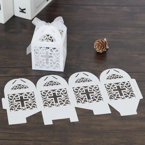 Détails de boîtes à cadeaux ajourées en forme de croix blanche avec rubans en soie