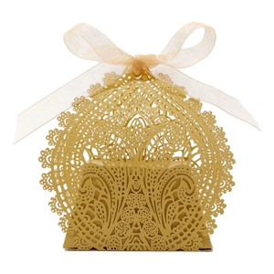 Macro shot of laser-cut hollow lace pattern on champagne gold wedding candy box