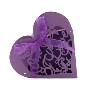 Detail of purple laser-cut heart favor box with floral patterns and a sheer ribbon bow