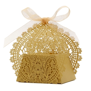 Macro detail of laser-cut lace pattern on golden gift box with organza ribbon
