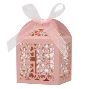 Détail de la boîte à bonbons rose nacré avec croix découpée au laser et ruban