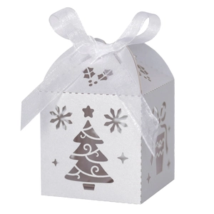 Detail of white laser-cut Christmas tree candy box with pearlescent paper and ribbon