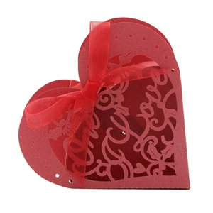 Red heart-shaped laser-cut wedding favor box with floral patterns and a silk ribbon bow