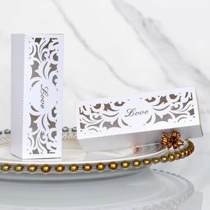 Detailed laser-cut white wedding favor box with Love script and floral patterns