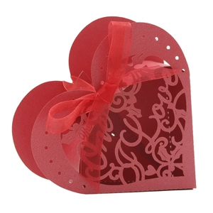 Detail of red heart-shaped laser-cut favor box with Love motifs and satin ribbon bow