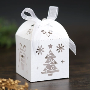 Detailed laser-cut white Christmas gift box with festive patterns and silk ribbon bow
