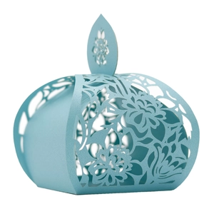 Macro shot of light blue laser-cut paper wedding candy box with floral hollow patterns