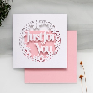 Close-up of laser-cut floral wreath and Just for You lettering on greeting card
