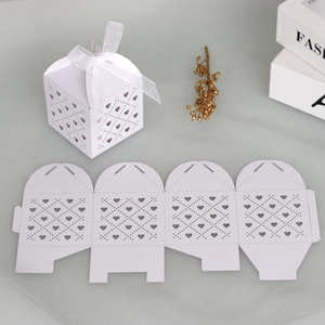 Detail showing the white laser-cut heart pattern on a wedding gift box with ribbon