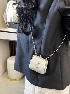 Chic silver mini crossbody lipstick bag with metal moon detail and ball chain strap
