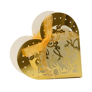 Detail of heart-shaped gold laser-cut wedding candy box with yellow ribbon bow