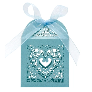 Macro detail of laser-cut heart patterns and blue organza ribbon on the candy box