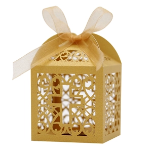 Détail de la boîte à bonbons dorée découpée au laser avec motifs croix et ruban en organza