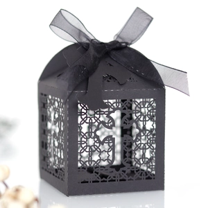 Detailed laser-cut black cross favor box with elegant black ribbon bow for celebrations