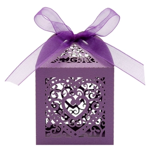 Detail of purple laser-cut candy box with elegant heart pattern and matching silk ribbon