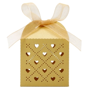 Detail of laser-cut heart pattern on gold gift box with an elegant ribbon bow
