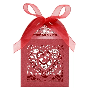 Close-up of red laser-cut heart favor box with decorative ribbon for wedding and party