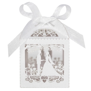 Detail of white laser-cut wedding favor box with romantic silhouette and satin bow