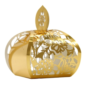 Macro detail of laser-cut gold wedding favor box with intricate floral hollow pattern