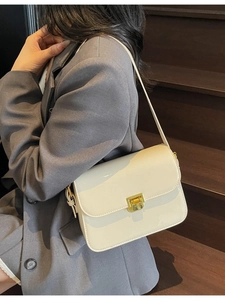 Chic cream glossy crossbody bag with gold square metal buckle on shoulder strap