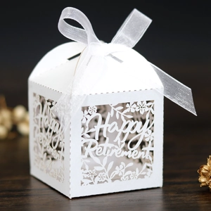 Gros plan de la boîte cadeau blanche découpée au laser Happy Retirement avec ruban chic
