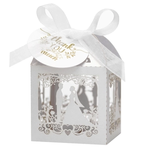 Close-up of white laser-cut wedding favor box with Thank You tag and silk ribbon bow
