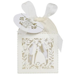 Detail of laser-cut white wedding favor box with bride and groom silhouette and ribbon