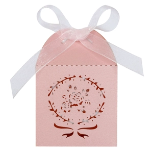 Détail de la boîte à dragées rose découpée au laser avec motif floral et ruban en soie