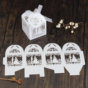 Laser-cut white wedding favor box with bride and groom silhouette and ribbon detail