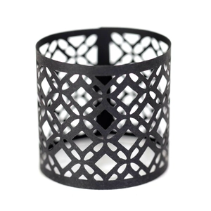 Detail of laser-cut gold napkin ring with intricate geometric hollow patterns