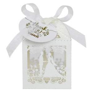 Macro detail of laser-cut white wedding favor box with Thank You tag and ribbon