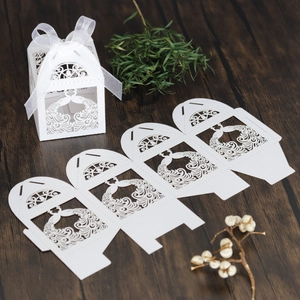 Detailed laser-cut peacock pattern on white candy box with ribbon and flat cardboard