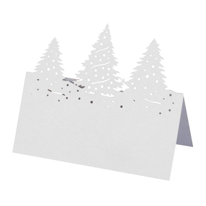 Détail de sapin de Noël découpé au laser sur un marque-place en papier blanc plié