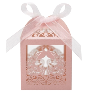 Close-up of pink laser-cut peacock candy box with elegant white ribbon bow detail