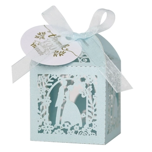 Detail of light blue laser-cut wedding favor box with ribbon and Thank You tag