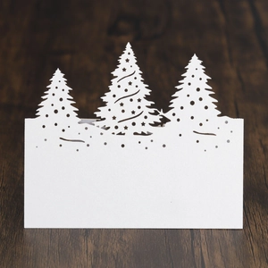 Détail du marque-place de Noël blanc découpé au laser avec rennes et sapins sur bois