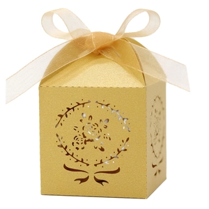 Détail du motif floral découpé au laser sur boîte à dragées dorée scintillante avec ruban
