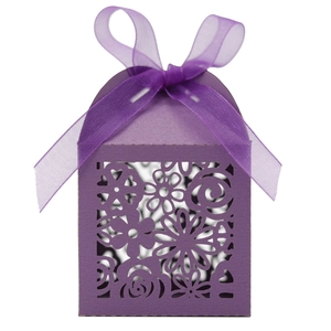 Gros plan sur la boîte à bonbons de mariage violet foncé avec motif floral découpé au laser