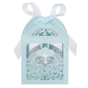 Detail of light blue laser-cut candy box with peacock patterns and white silk ribbon bow