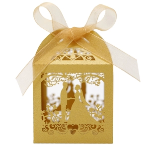 Detail of gold laser-cut wedding candy box featuring a romantic couple silhouette and ribbon