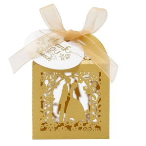 Detail of laser-cut wedding favor box with champagne gold ribbon and thank you tag