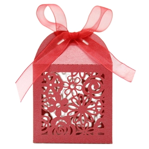 Détail de la boîte à bonbons rouge découpée au laser avec motifs floraux et ruban en organza