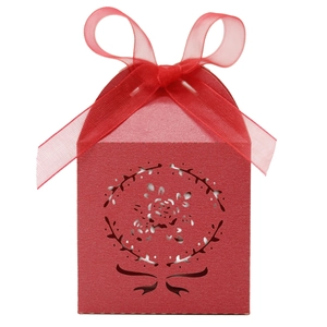 Détail d'une boîte à bonbons rouge découpée au laser avec motifs floraux et ruban