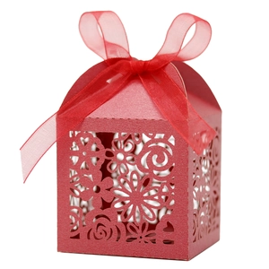 Vue détaillée d'une boîte cadeau rouge découpée au laser avec motifs floraux et ruban