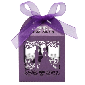 Detail of purple laser-cut wedding favor box featuring silhouette of a couple and ribbon