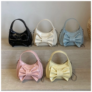 Détail de sacs seaux en cuir verni brillant en cinq couleurs avec de grands nœuds