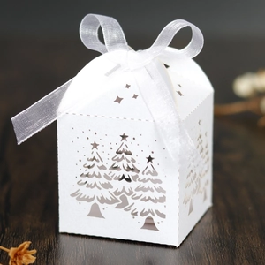 Detailaufnahme der weißen Weihnachtsbaum-Geschenkbox mit eleganter Schleife aus Satinband