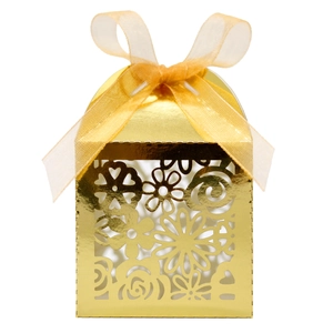 Détail de boîte à bonbons dorée découpée au laser avec motif floral et ruban organza