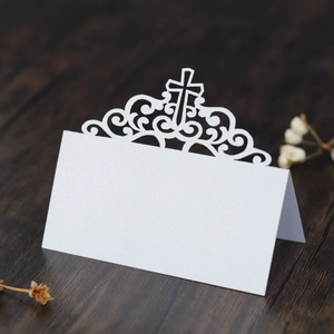 Détail du marque-place blanc découpé au laser avec texture papier perlé et croix
